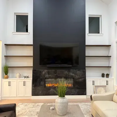 Black fireplace accent wall with floating shelves and built-in cabinets — Plano, TX | Goldstar Renovations